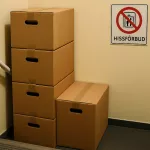 “Flyttkartonger staplade i smal trappa utan hiss – symboliserar utmaningar vid flytt med hissförbud, tunga lyft och behov av planering i trånga utrymmen”